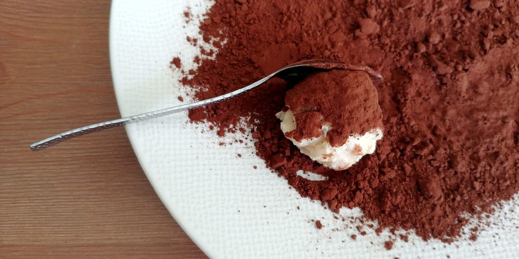 cuillère de tiramisu qui se roule dans le cacao